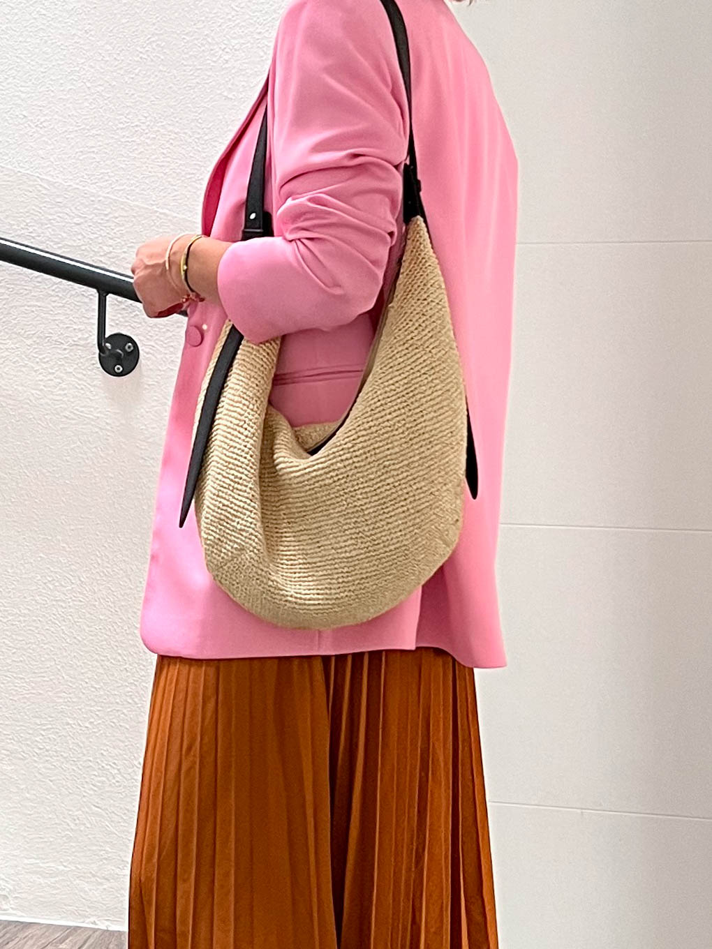 Herbst Outfit zum Thema Pink kombinieren: Brauner Midirock, pinker Blazer, Nieten-Boots und Strohtasche. Alle Outfit-Details auf whoismocca.com